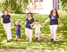 Schüler*innen laufen mit Kindern über die Wiese
