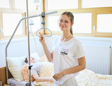 Schülerin stellt bei Pflegepuppe Rollklemme ein
