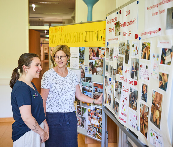 Schülerin und Lehrerin stehen an der Tafel