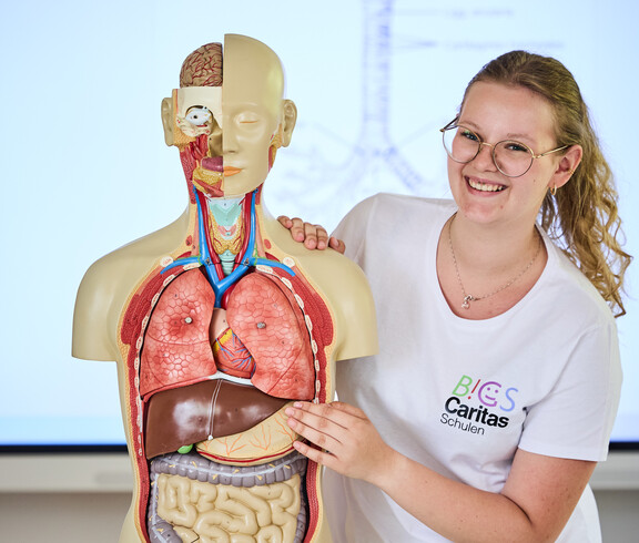 Schülerin erklärt im Pflegeunterricht Torso