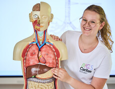 Schülerin erklärt im Pflegeunterricht Torso